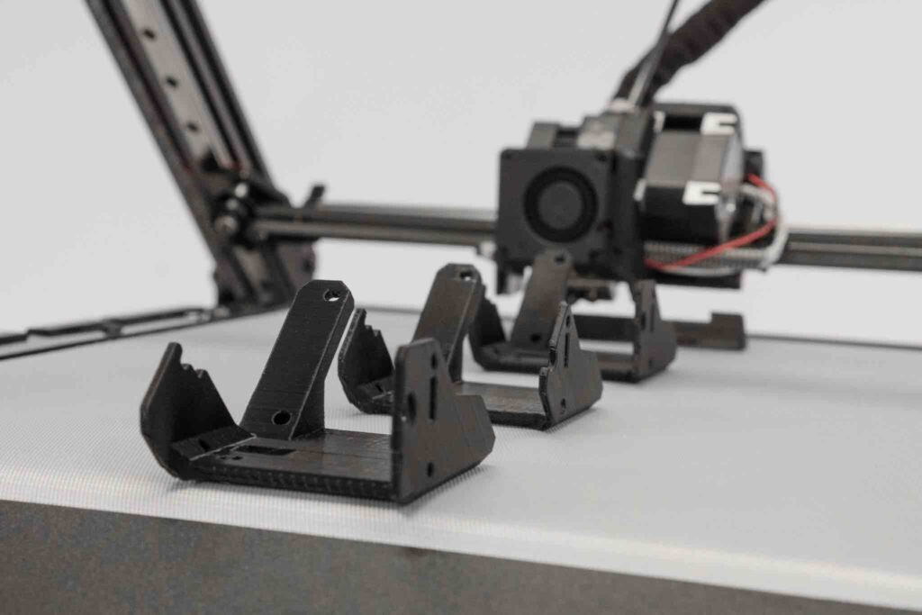 The One Pro features a conveyor belt as a print bed enabling infinite 3D printing