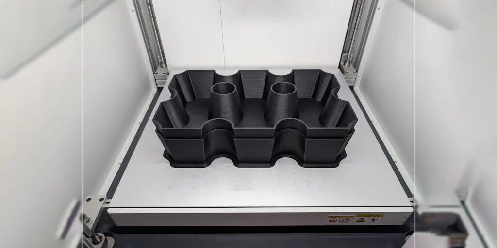 Large black 3D printed composite part with internal ribbing and cylindrical features occupying the full 800 by 800 mm build plate of the Peopoly Giga 800